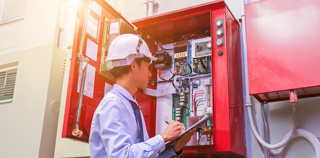 Engineer calculating fire alarm system price components during the design stage